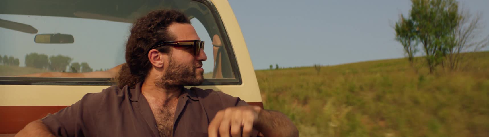 A man is riding in the back of a pick up truck
