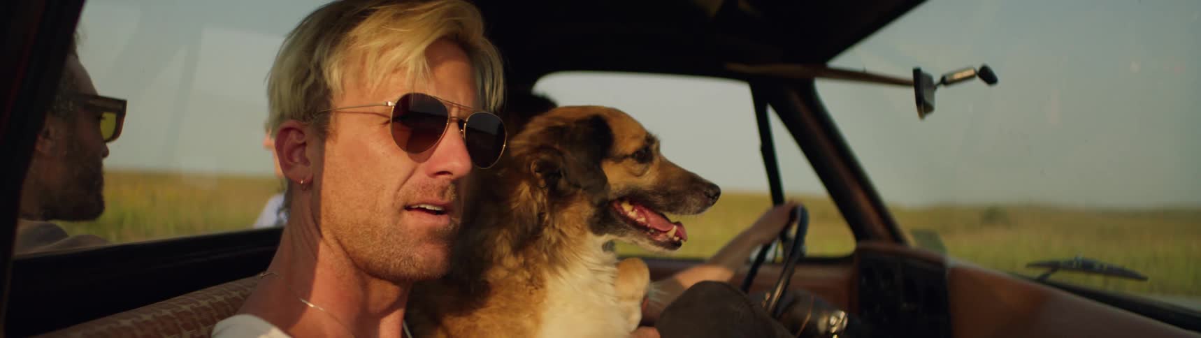 Man holding his dog in a truck
