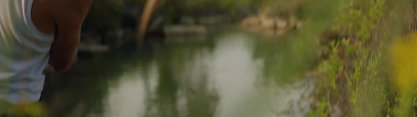 A man skips rocks in to a river
