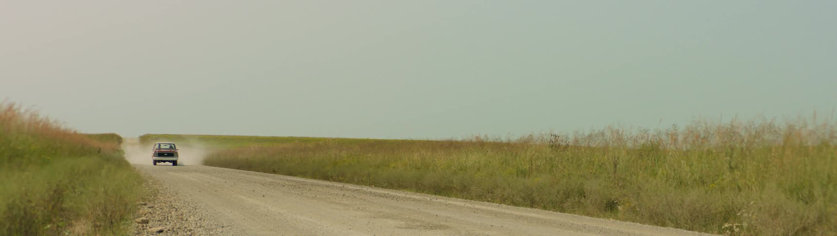 Truck driving on dirt road through the countryside