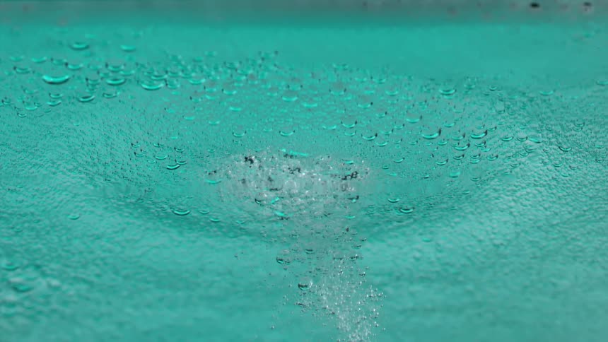 Water being disturbed by a drop creating ripples in the water