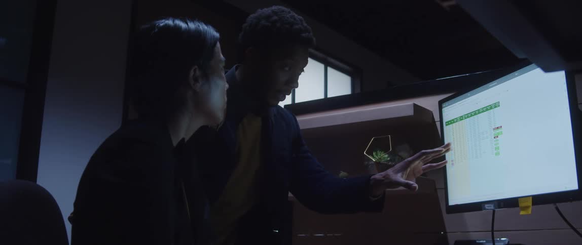 Two employees are working in the office and looking at the computer