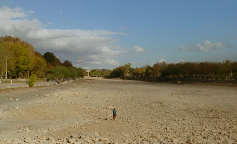 A man walks through an empty gravel lot