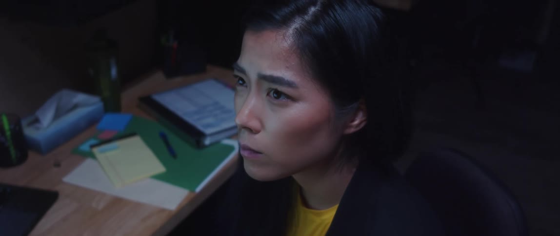 A woman staring and thinking contemplatively near her desk