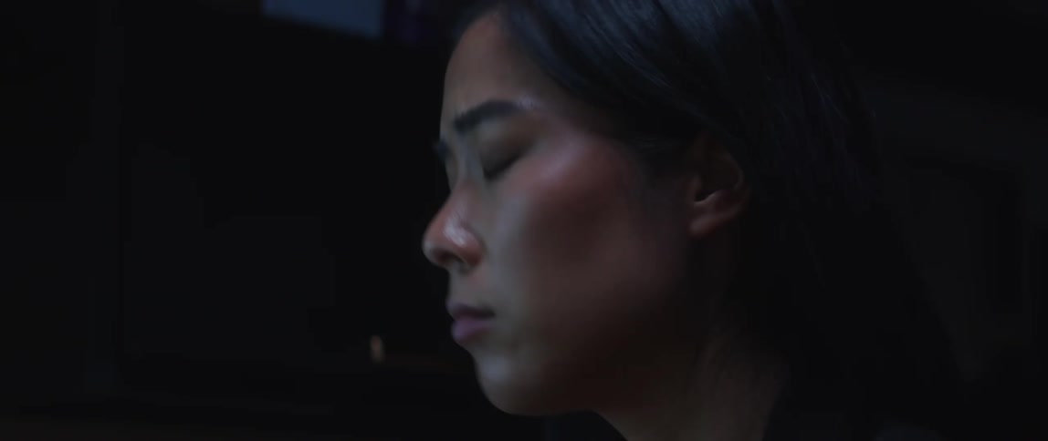 A young asian woman is inside and working on something