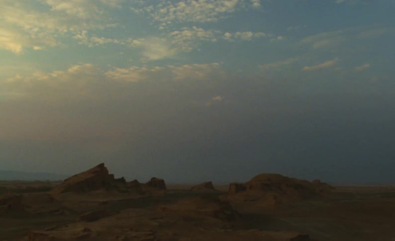 The sun is rising on the desert