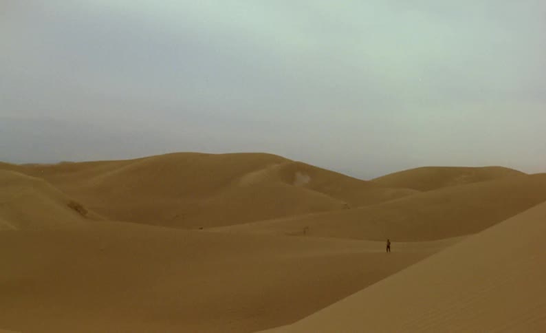 A person running down a sand dune