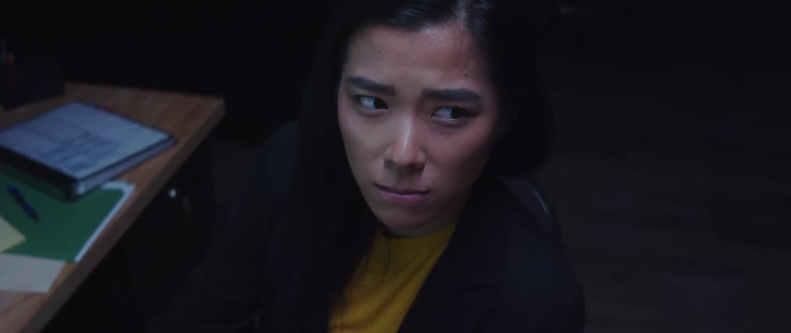 A woman sitting at a desk looking off contemplatively squinting her face