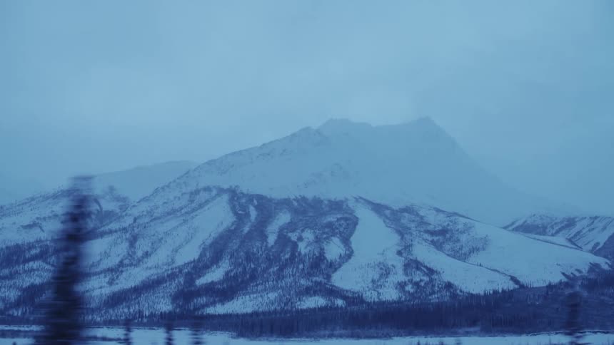 A view of a mountain during the winter is displayed