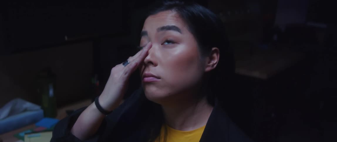 A young woman is tired working at the office late at night