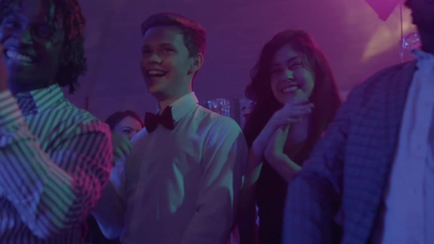 A group of friends laugh and clap toward each other on the dance floor