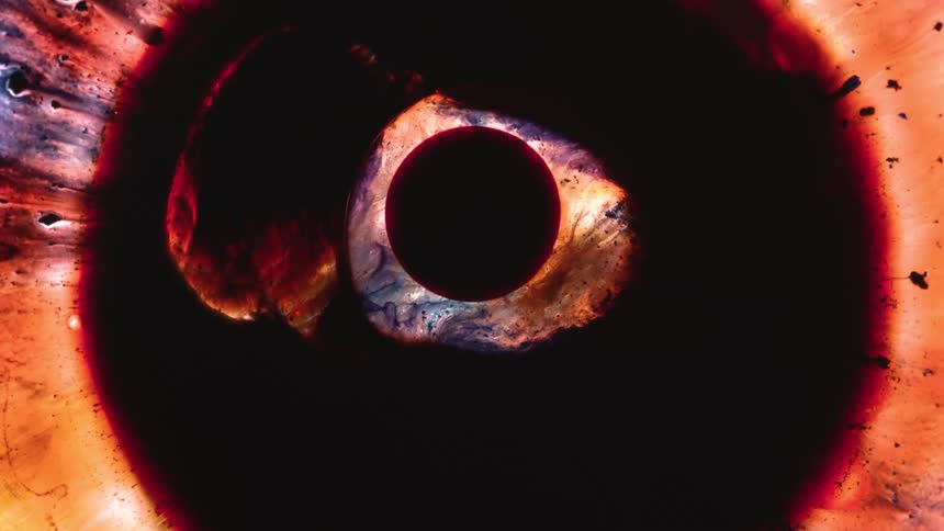 A colorful smoky pattern moves around a circle within a bigger circle