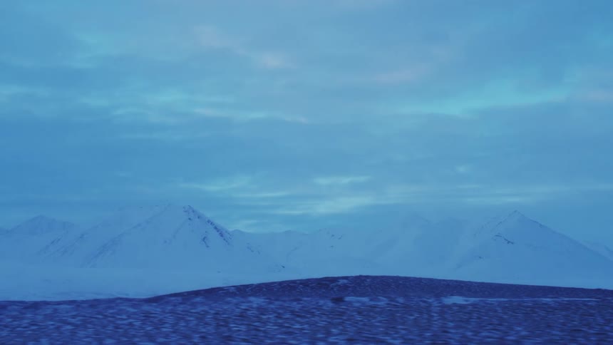 A mountain range is covered with a thick layer of snow