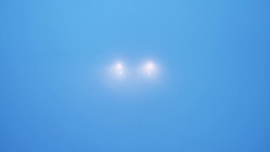Headlights of a vehicle as it drives through a snow storm