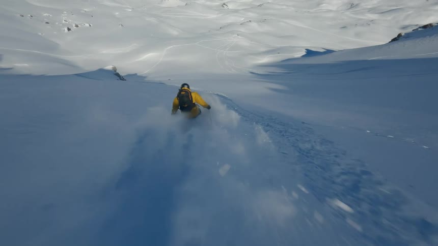Man skiing through the mountains and doing tricks