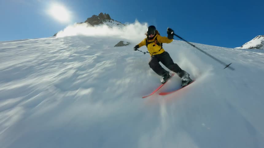 A man is skiing down a steep mountain