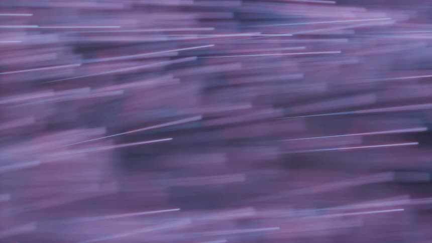 Fast moving particles are streaming across the frame