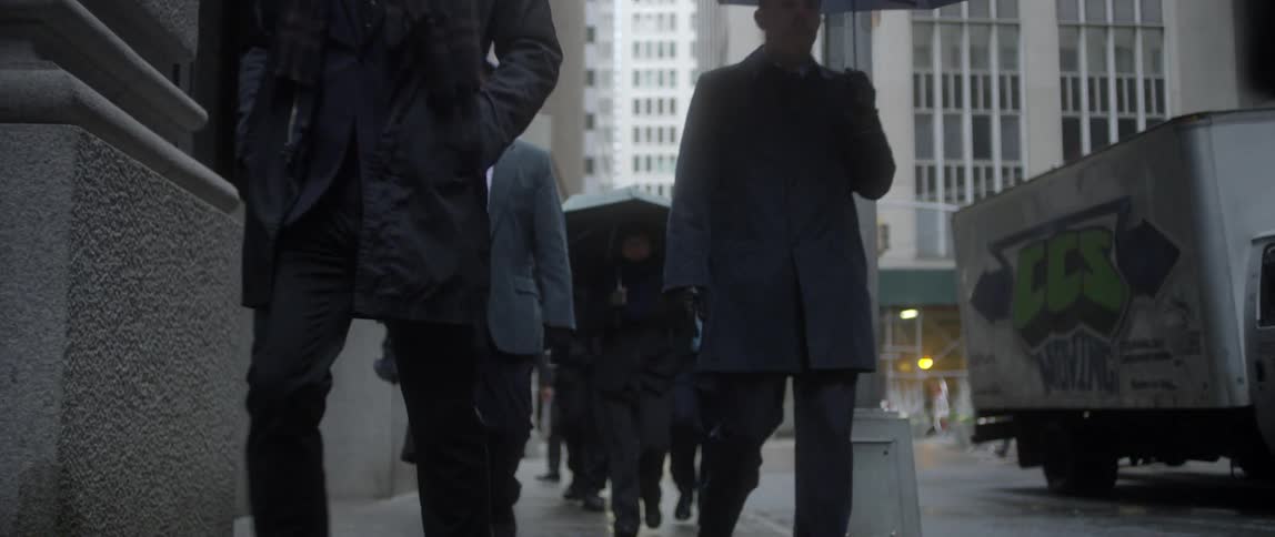 People travel down a city street in the rain