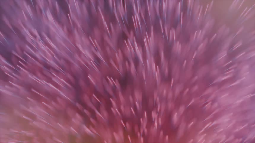 Colorful particles swirling and rushing at light speed at the camera