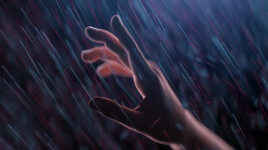 A hand is stretching our toward the light as illuminated particles are flying down