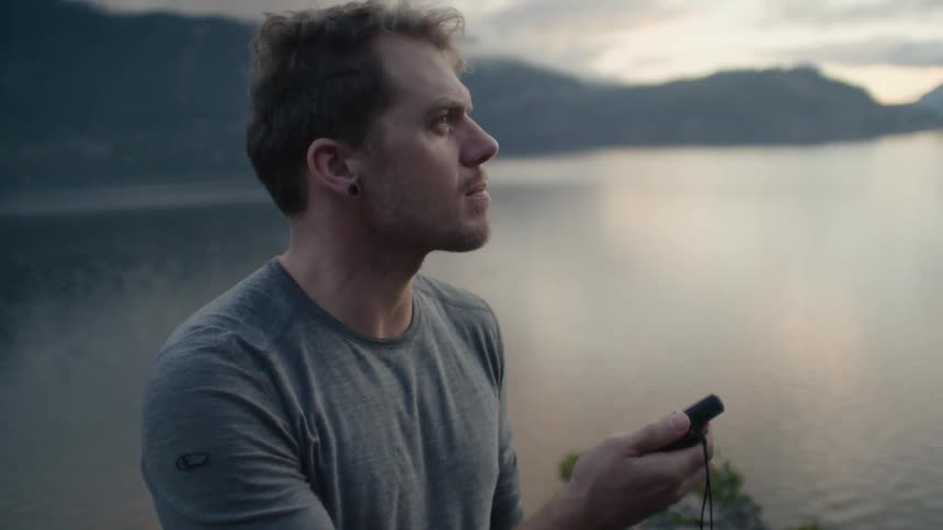 A man looking around tracking something with a device in his hand