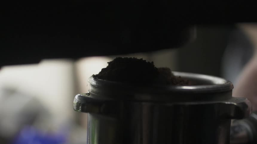 Coffee grounds fall into a tin