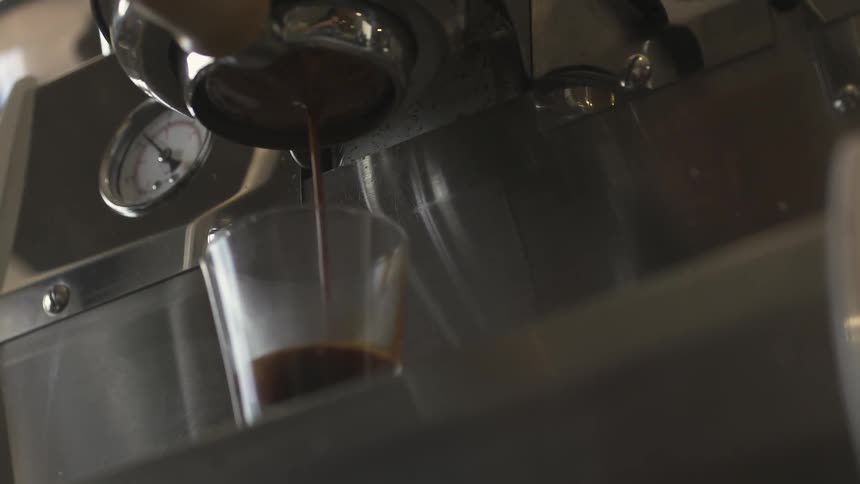 Coffee pours from a coffee machine