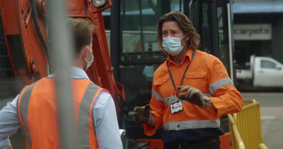 A boss and employee talking at a construction site
