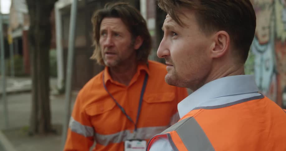 A boss talks to his employee on a city street