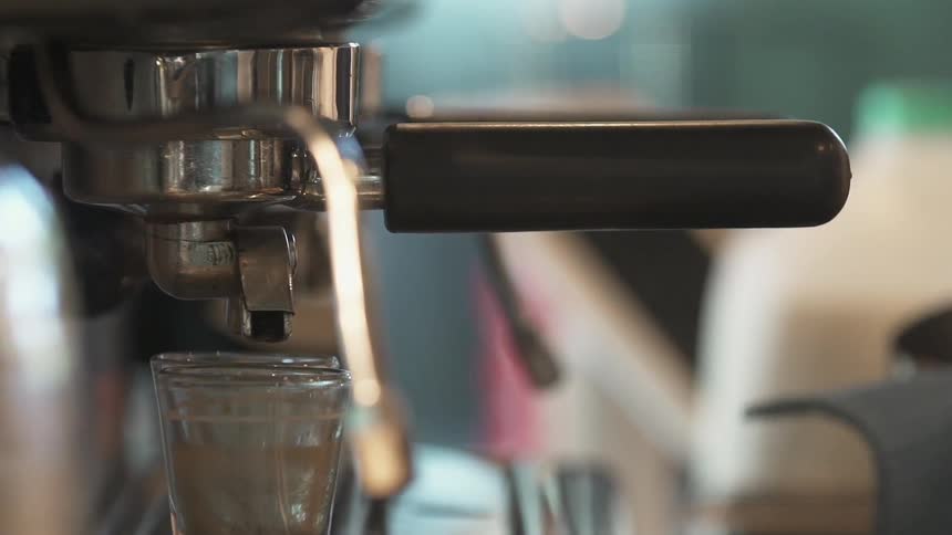 A person makes an espresso