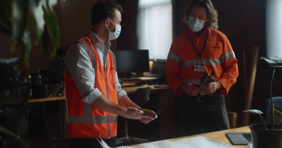 Two men in an office look at samples of wood