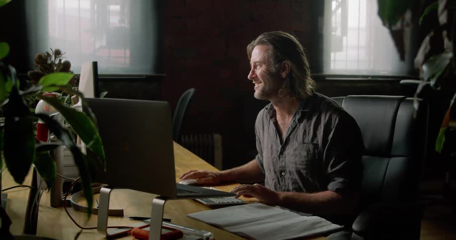 Male architect sitting at the desk speaks to his coworker in the office