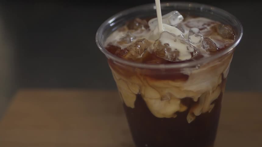 Cream is poured into iced coffee