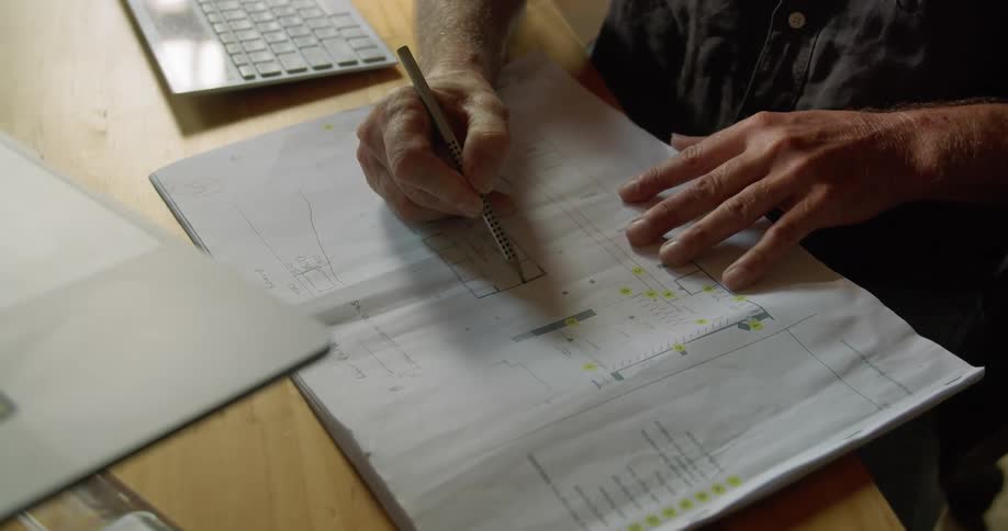 A man writes on a piece of paper sitting at a desk