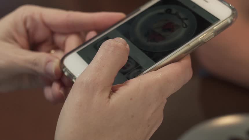 A person pushes buttons on their phone
