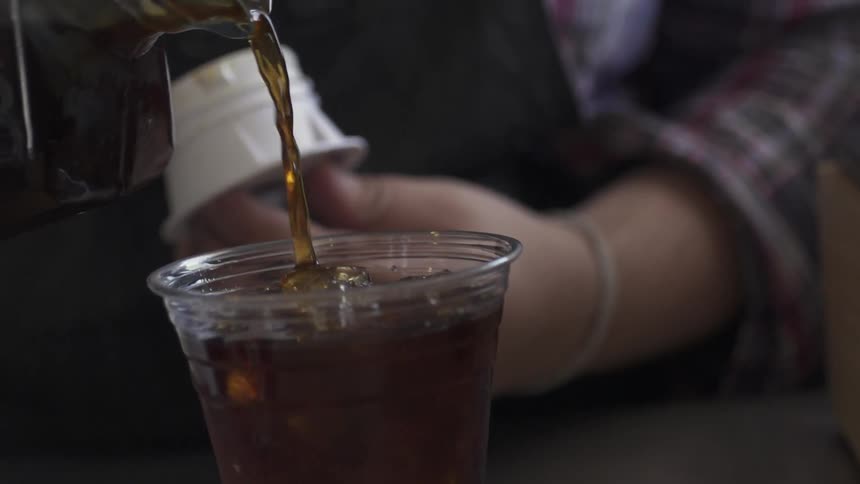 A drink is poured into a cup