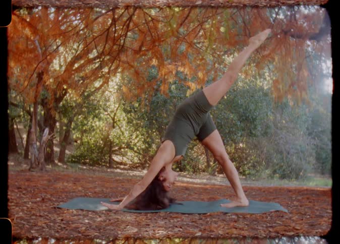 A woman doing yoga in a forested area in autumn