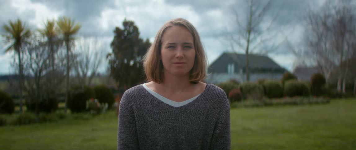 A woman is posing in her yard
