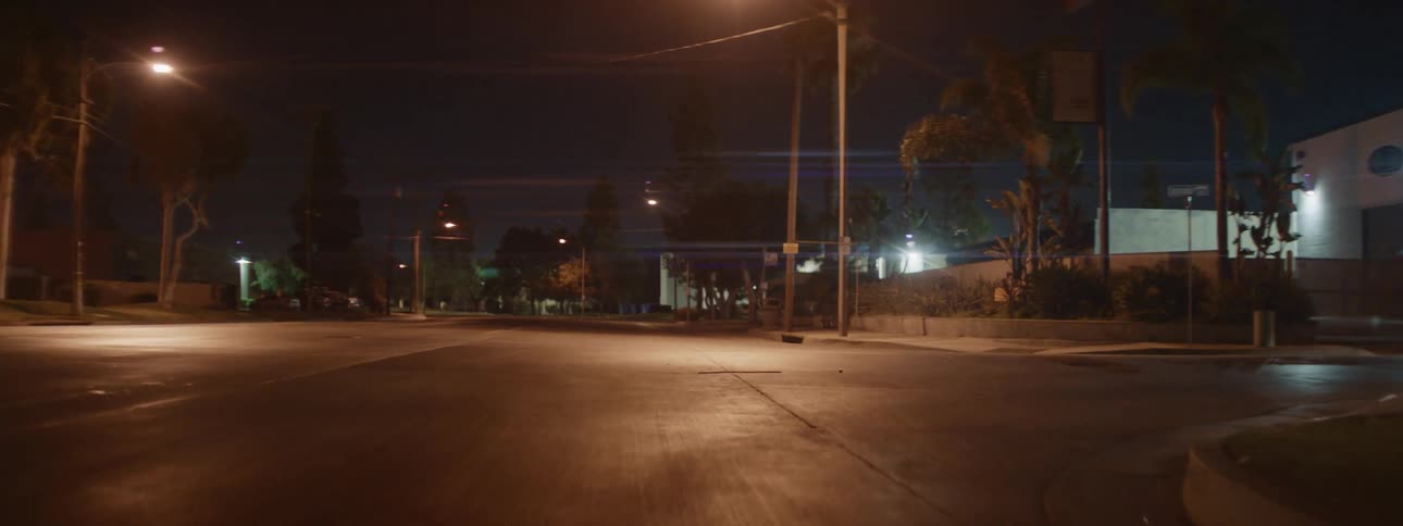 Black car escapes police car in the street at night