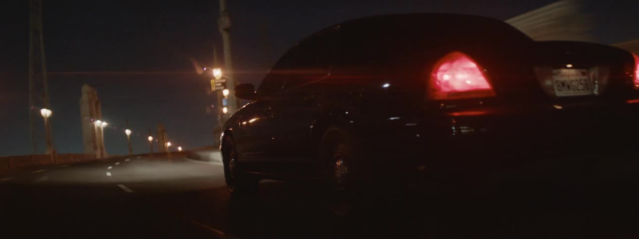 Police car chases black car driving on highway in the city