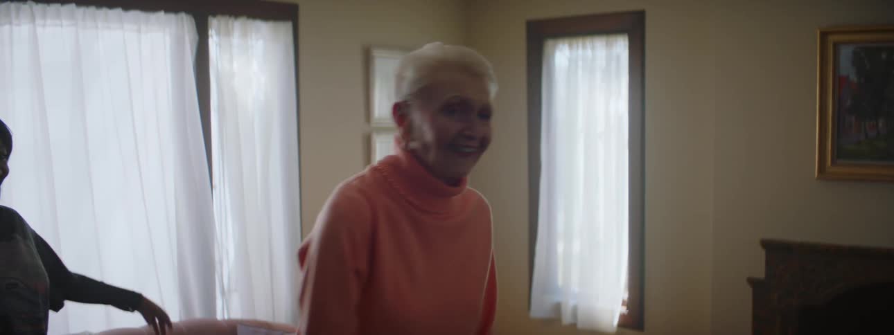 Two women are dancing together in a living room