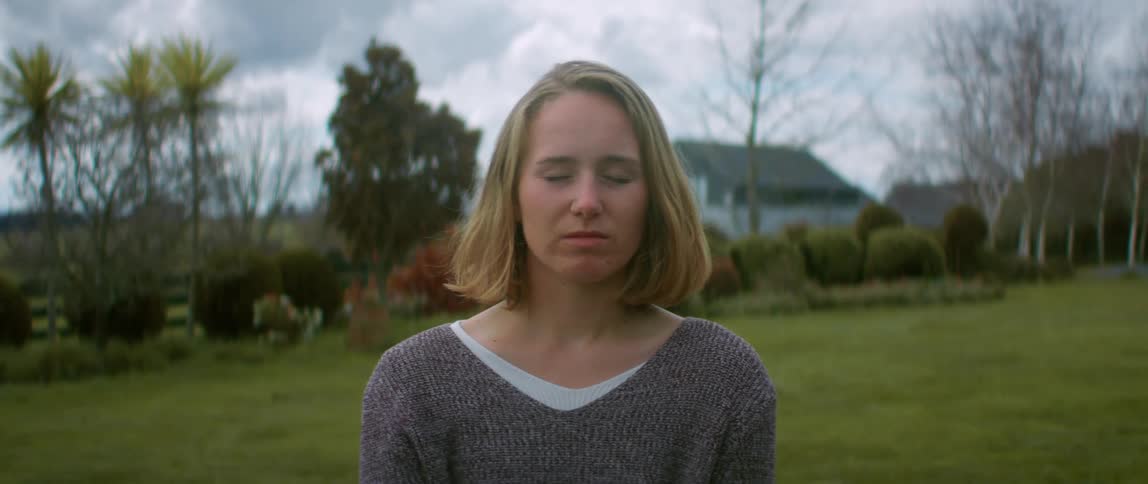 A woman is posing in her yard