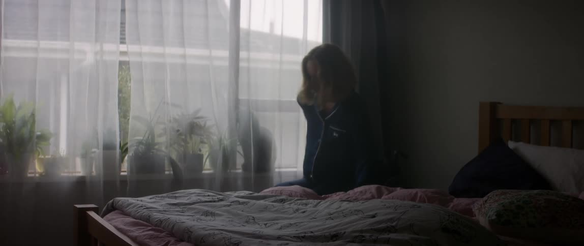A woman gets up from bed and gets in her wheelchair