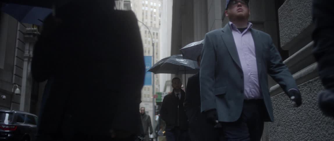 People are walking together down a city sidewalk