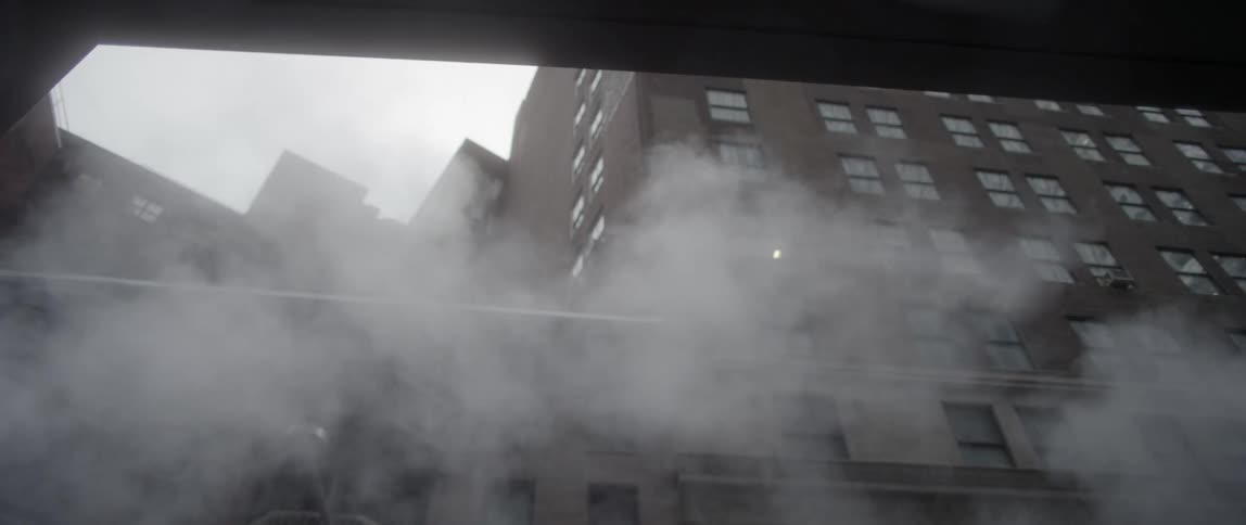 Steam blows by a tall building