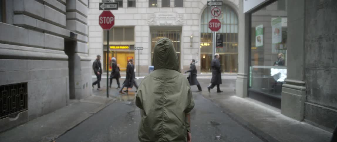 Someone standing in an alley as other people cross the alleyway