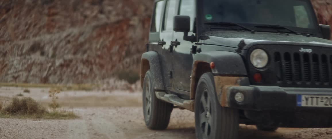 Black jeep drives down road near the mountain