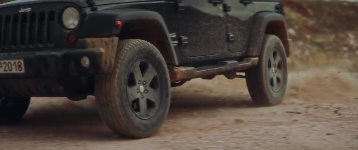 Black jeep drifts to the left in the field