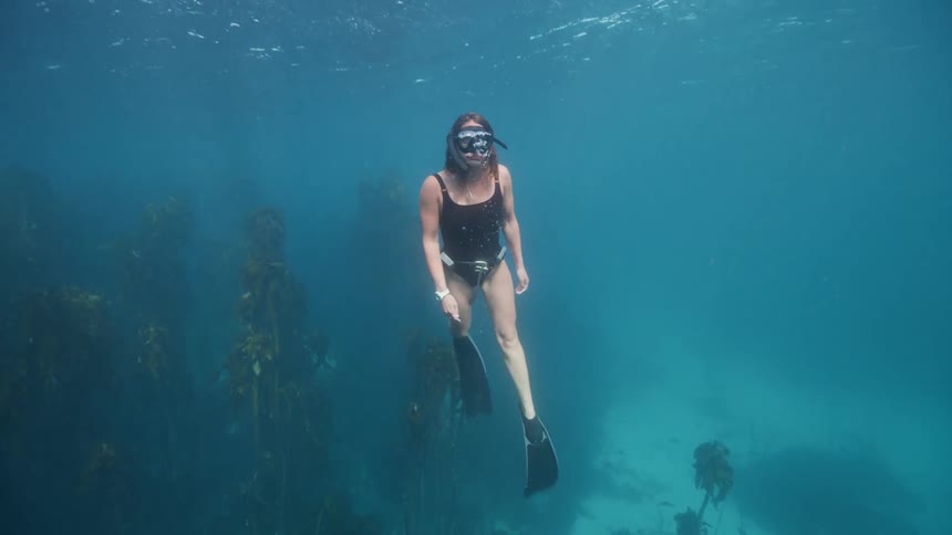 A woman is swimming in the ocean water