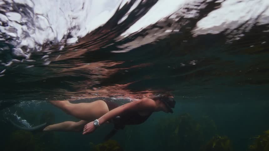 A woman is swimming under the ocean water